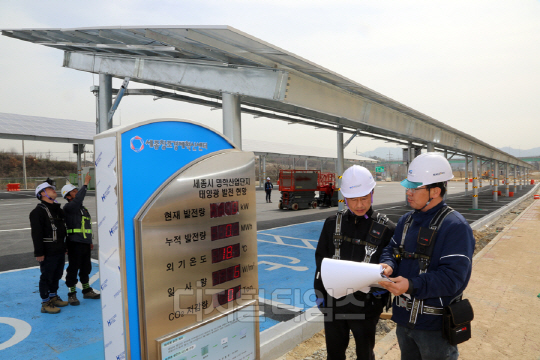 지난 1일 세종시 연동면 명학산업단지에 설치된 태양광발전소에서 현장 관계자들이 발전설비를 점검하고 있다. <SK그룹 제공>